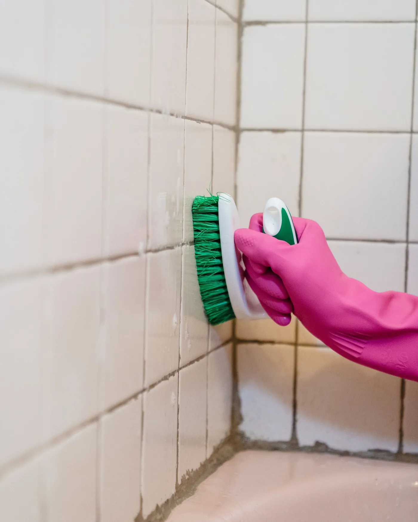 Kakelfogarna skrubbas med borste i badrummet