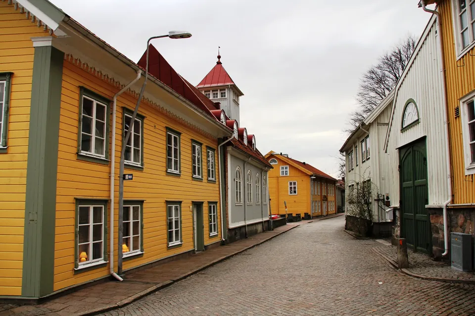Västra gatan i Kungälvs gamla stad med gula trähus och kullersten